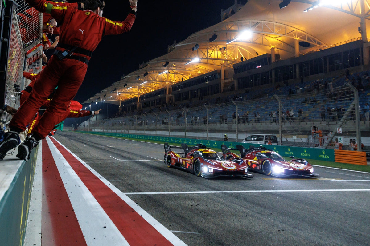 The #50 and #51 Ferrari 499P Hypercars cross the finish line at the 8 Hours of Bahrain, with team members in red jumping to celebrate their 2025 WEC World Championship victory.